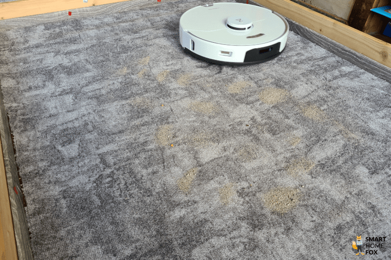 Roborock S7 Pro Ultra Saugroboter reinigt Sand auf einem kurzflorigen Teppich